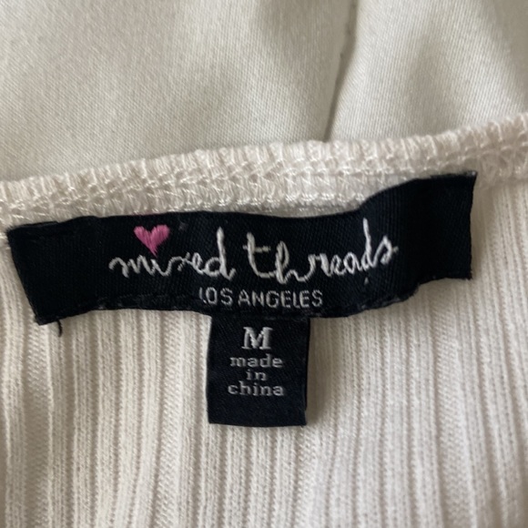 This is a medium sized white cropped tank top with a button down. - Picture 3 of 4